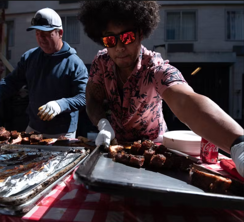men in the sun grilling and serving ribs