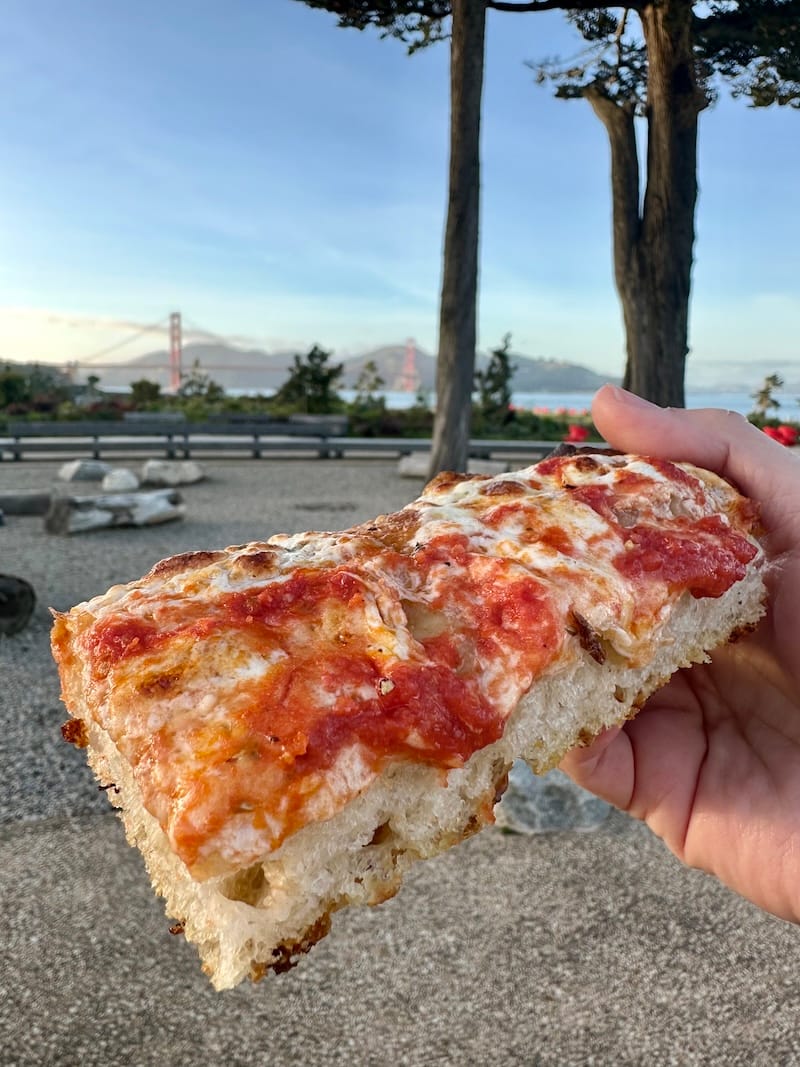A slice of focaccia pizza at sunset at Il Parco. Photo: © tablehopper.com.