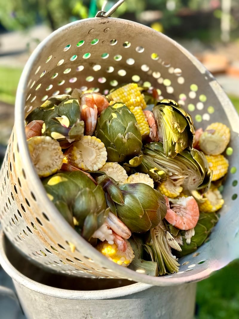A fantastic family seafood boil, with shrimp, artichokes, Dungeness crab, corn, two kinds of sausage, clams, potatoes, and a whole lotta garlic butter. Photo: © tablehopper.com.