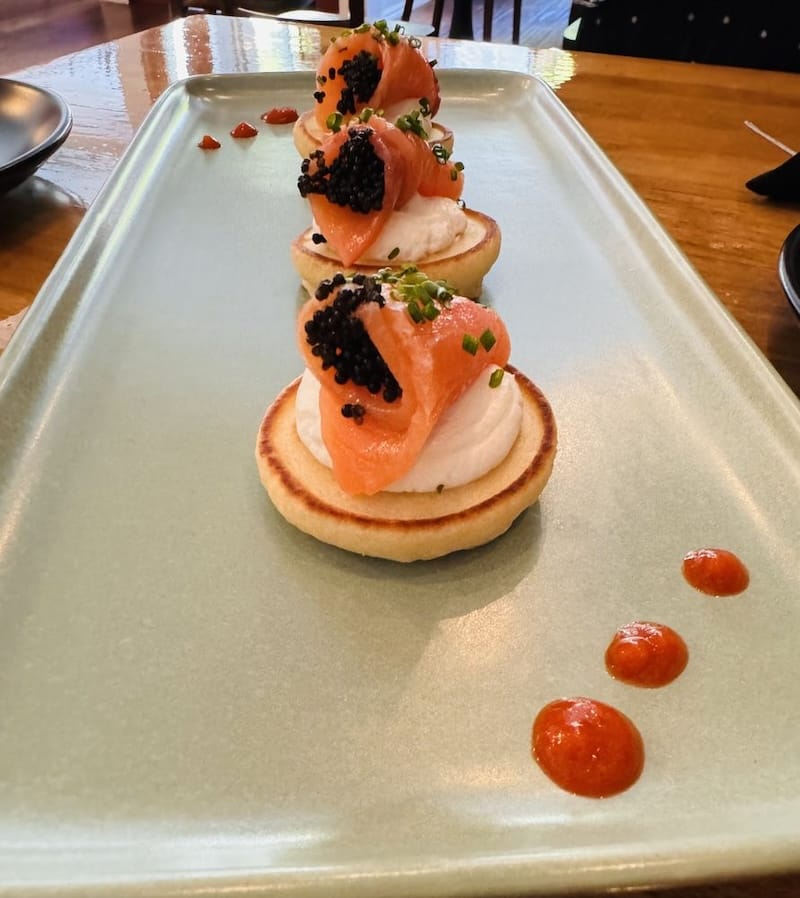 Cold-smoked salmon blini with black caviar are on the extensive menu of small plates at The Crumb. Photo courtesy of The Crumb.