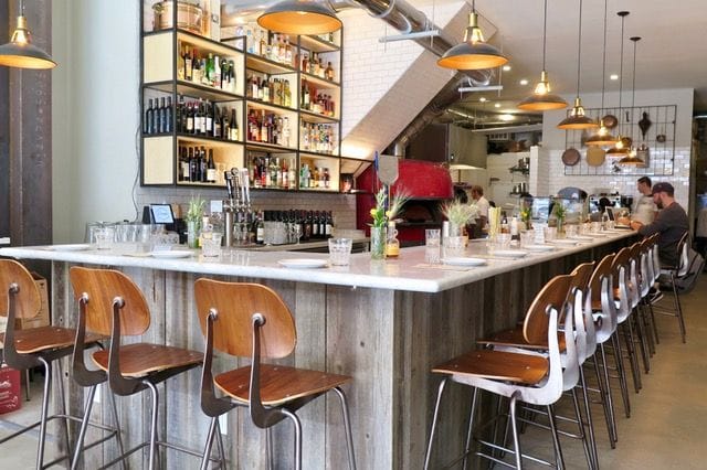 The spacious bar overlooking the open kitchen and wood-fired oven at Il Casaro Castro. Photo: © tablehopper.com.